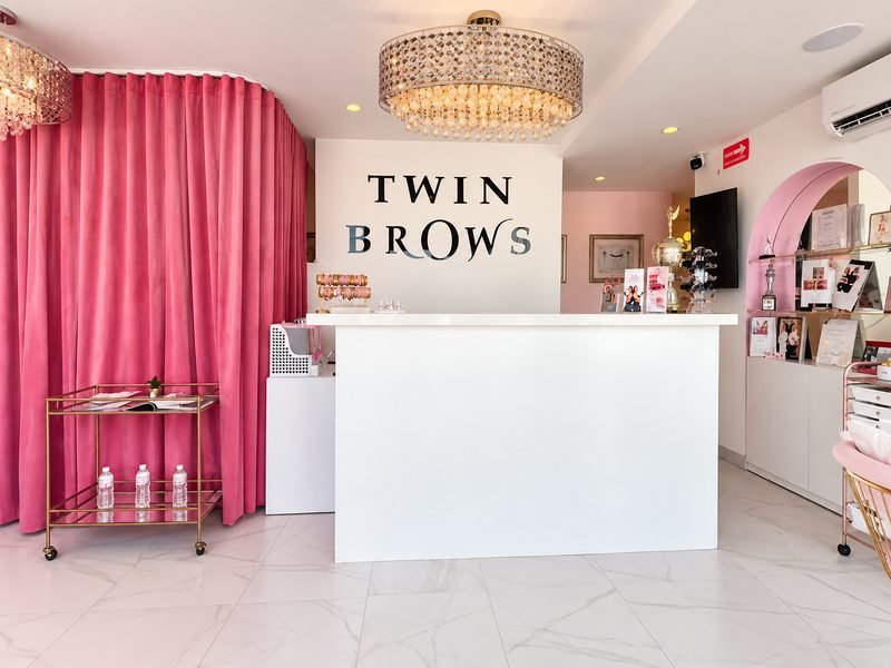 Recepción de Twin Brows con nuestro letrero, candelabro de cristal y cortinas de terciopelo rosa