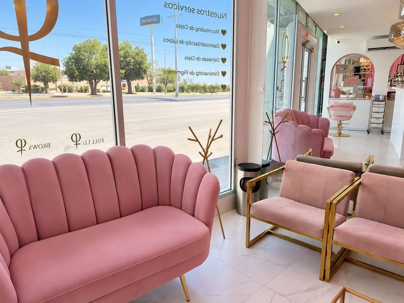 Sala de espera de Twin Brows con sofá de terciopelo rosa junto al ventanal